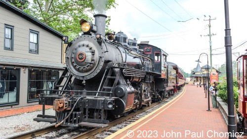 The noon train is leaving with New Hope & Ivyland #: 40 in the lead. The #: 40 is a Baldwin Built 2-8-0 Consolidation type steam locomotive built in 1925. It's looking very good as it is about to cross Bridge Street on its departure from the New Hope Station.