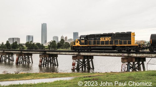 A few seconds later, the WAMX #: 4142 pulls it's long string of cars out onto the bridge over the Oklahoma River. The skyline of Oklahoma City provides a nice backdrop on this dismal day.