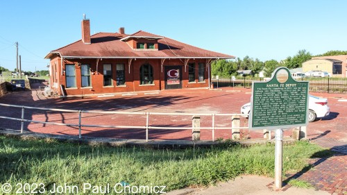 This photo of the sunny-side of the Santa Fe Depot in Guthrie, OK shows the historical marker summarizing the history of the building.