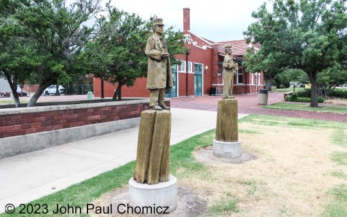 These wood carvings of a conductor and an engineer stand outside the Norman Santa Fe Depot in Norman, OK.