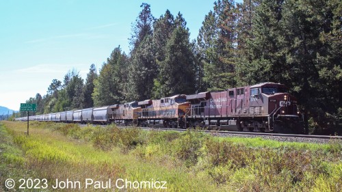 This three, well now two, railroad locomotive lash-up has UP, KCS, and CP as they idle on the UP Spokane Subdivision with this Canada-bound hopper train, in Sandpoint, Idaho.