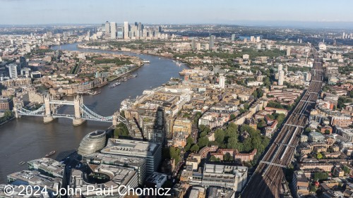 "The Shard", is the tallest building in London and not only provides beautiful views of London but also of London's extensive rail network. Here, to the right, multiple trains arrive and depart out of the London Bridge Station, which is right under the Shard. Meanwhile, to the left, the Thames, Tower Bridge, and the skyline of Canary Wharf provide a beautiful backdrop.