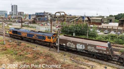 Unlike in the U.S, in the U.K., each rail company has multiple liveries for their units. This time, a westbound GB Railfreight empty hopper train led by British Rail Class 66 #: 66771 passes through Willesden Junction, London, UK.